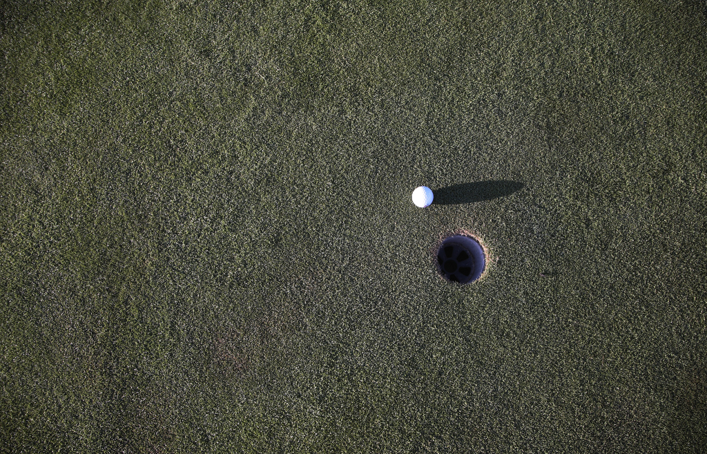 Golf ball next to hole